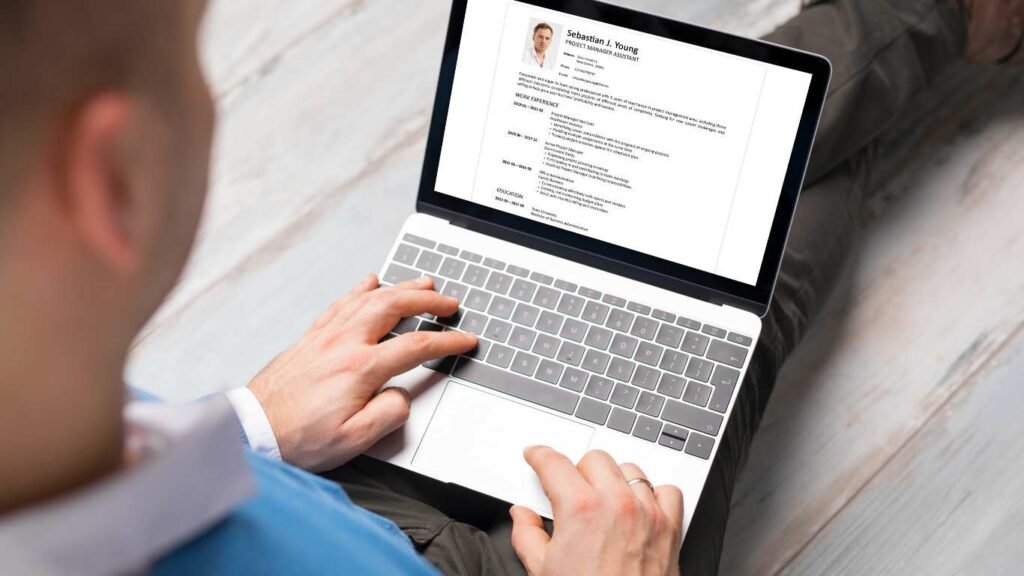 Professional creating a resume on a laptop, demonstrating strong job search skills for career advancement.